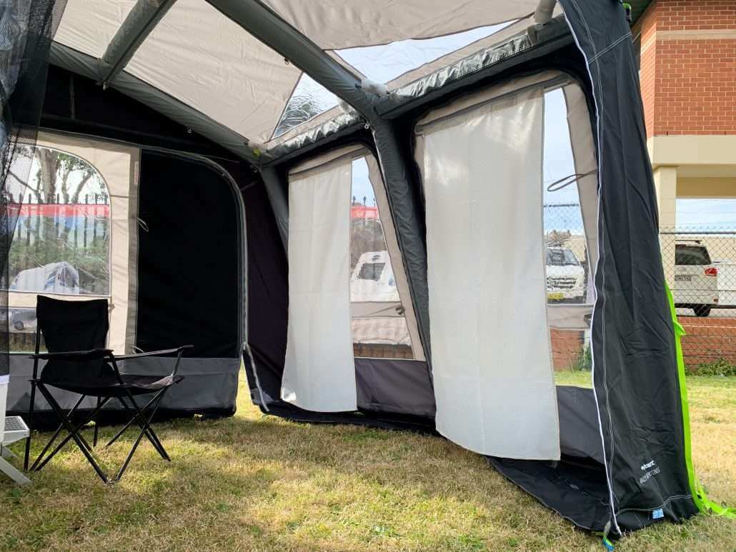 Dometic inflatable annex displayed with curtains and a chair inside it.